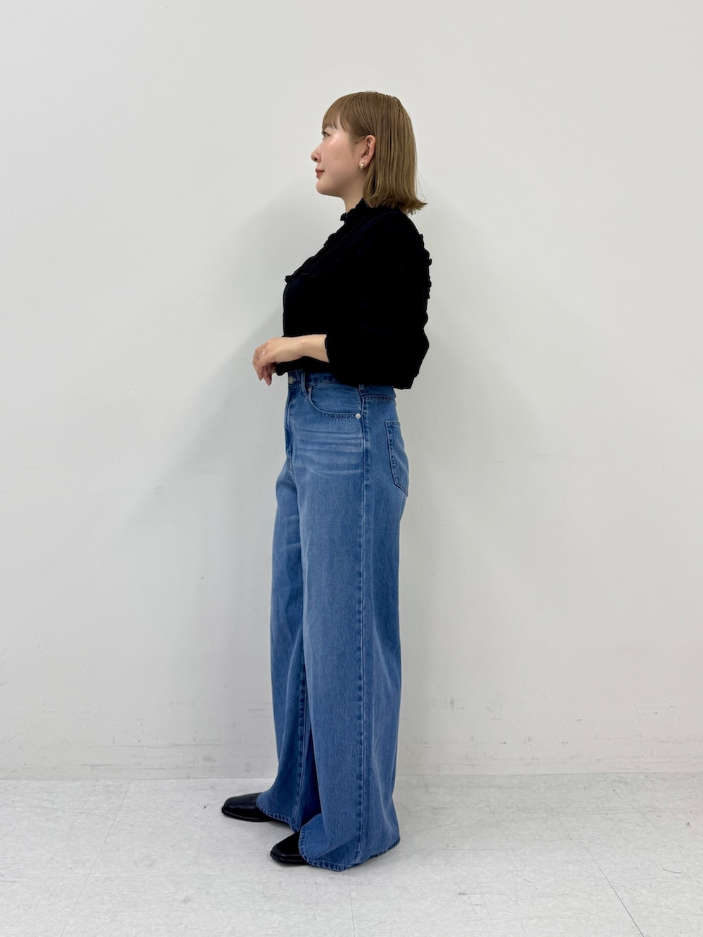 ブラック系のシャツ/ブラウス、ブルー系のデニムパンツ、ブラック系のスリッポンを着用したレディースの春コーディネートの2枚目の写真