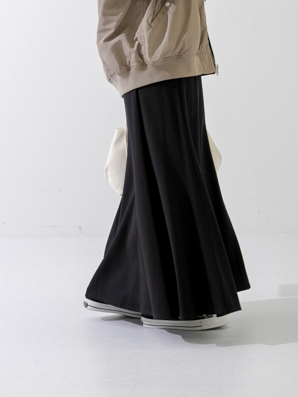 ホワイト系のトートバッグ、ブラック系のTシャツ/カットソー、ブラック系のスカートを着用したレディースの春コーディネートの5枚目の写真