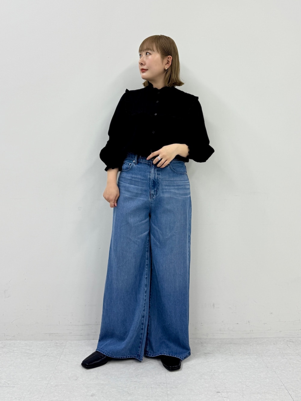 ブラック系のシャツ/ブラウス、ブルー系のデニムパンツ、ブラック系のスリッポンを着用したレディースの春コーディネートの4枚目の写真