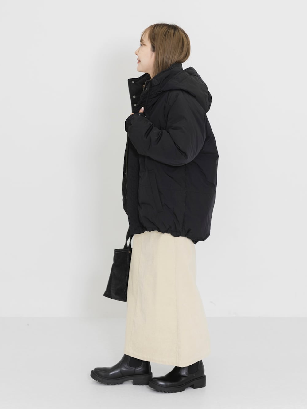 ホワイト系のTシャツ/カットソー、ホワイト系のスカート、グレー系のトートバッグを着用したレディースの冬コーディネートの3枚目の写真