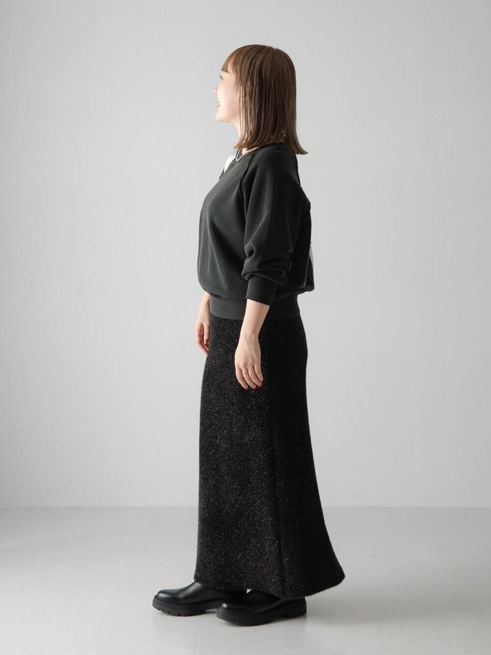 ブラック系のスカート、ブラック系のスウェット、シルバー系のショルダーバッグを着用したレディースの秋コーディネートの2枚目の写真