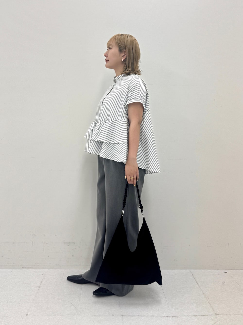 ホワイト系のシャツ/ブラウス、グレー系のその他パンツ、ブラック系のトートバッグを着用したレディースの夏コーディネートの2枚目の写真