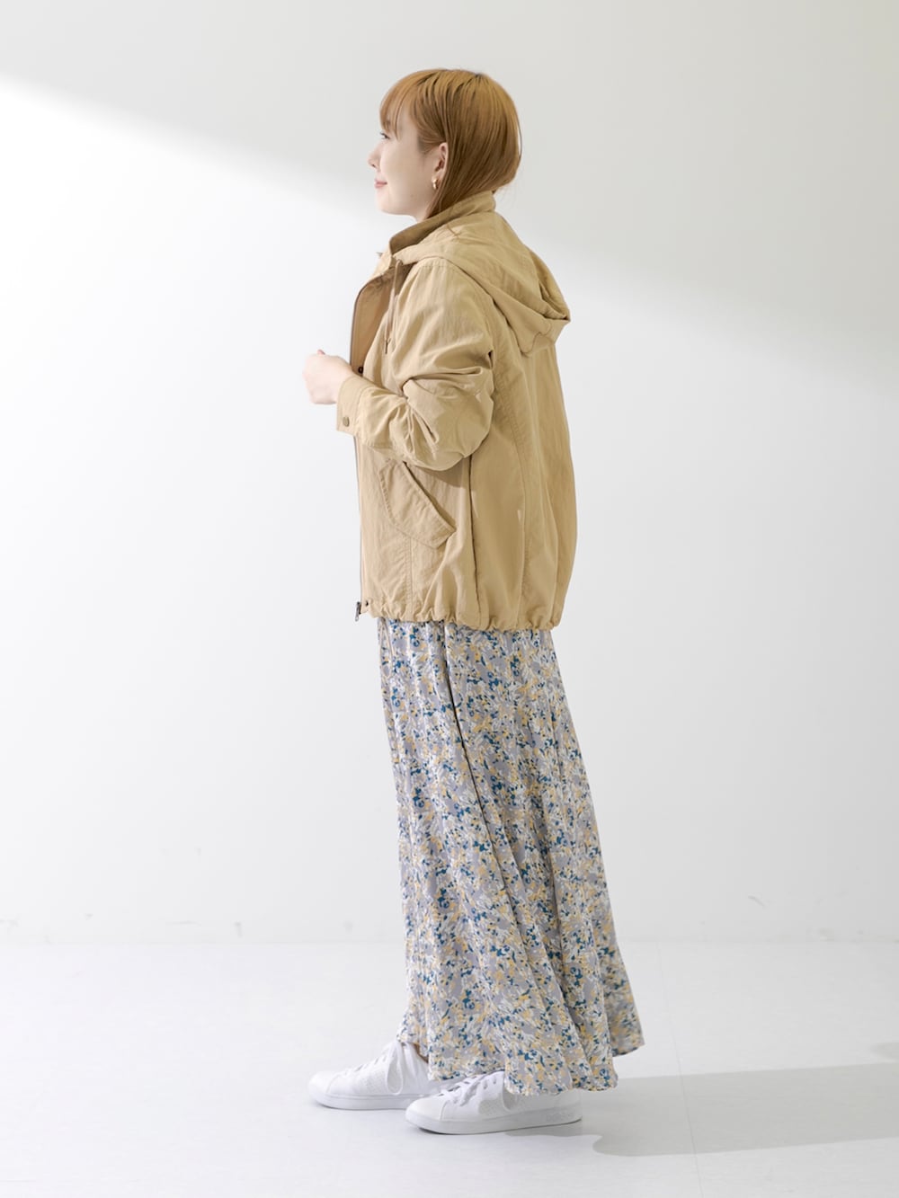 ブラウン系のハンドバッグ、ブラック系のTシャツ/カットソー、ベージュ系のマウンテンパーカーを着用したレディースの春コーディネートの2枚目の写真