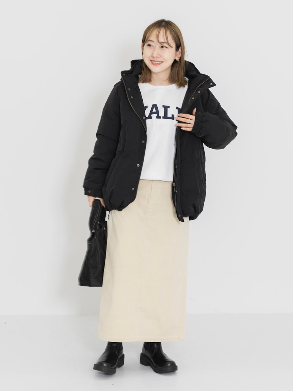 ホワイト系のTシャツ/カットソー、ホワイト系のスカート、グレー系のトートバッグを着用したレディースの冬コーディネートの2枚目の写真