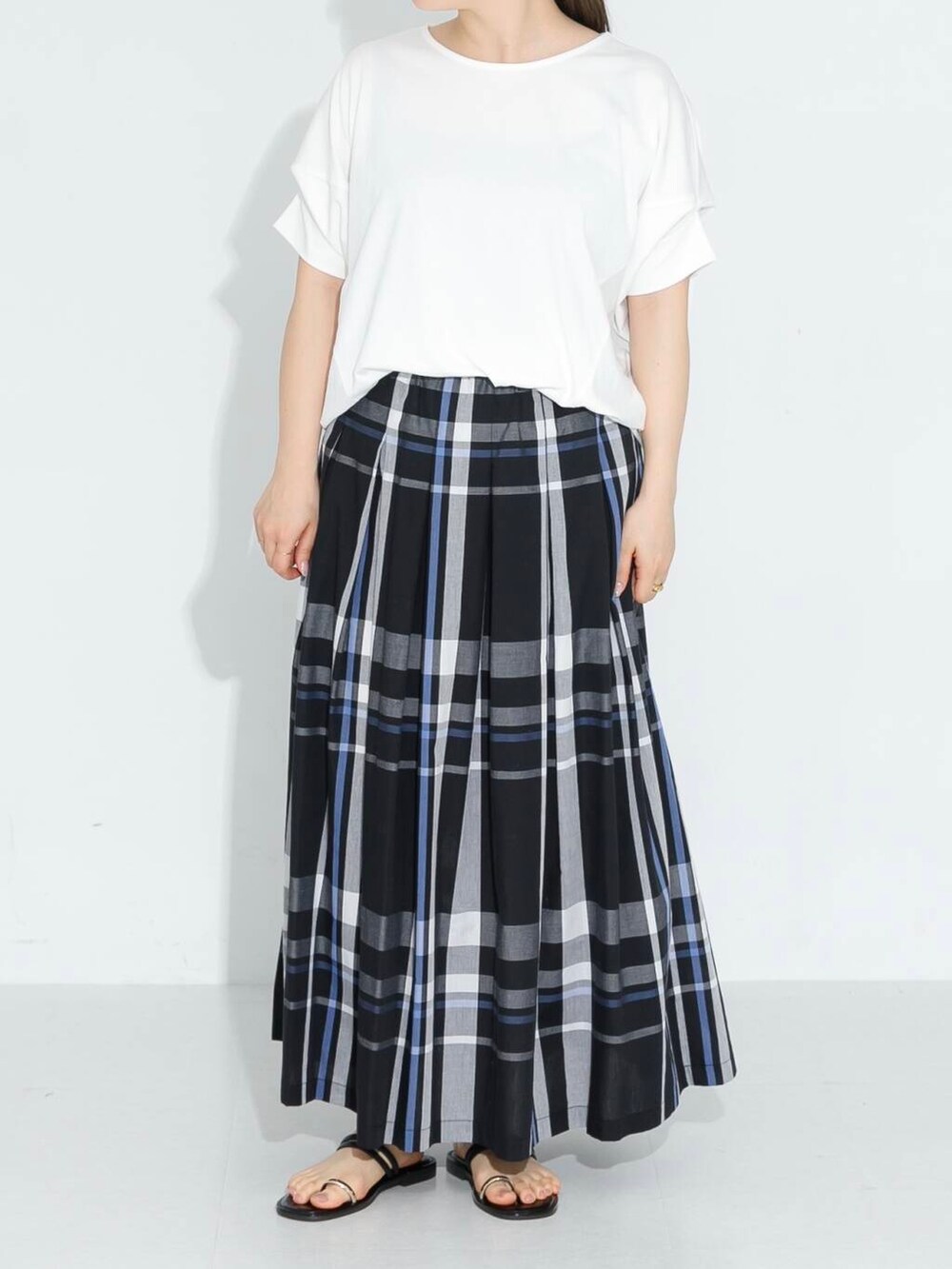 ブラック系のスカート、ホワイト系のTシャツ/カットソーを着用したレディースの春コーディネートの4枚目の写真