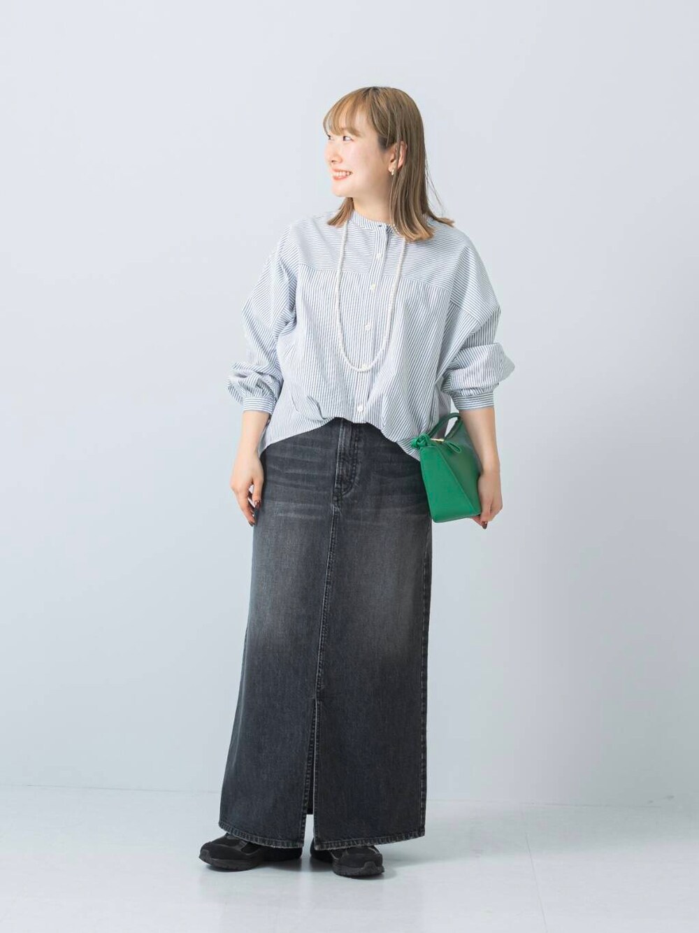 ブラック系のスニーカー、ブラック系のスカート、ホワイト系のシャツ/ブラウスを着用したレディースの冬コーディネートの4枚目の写真