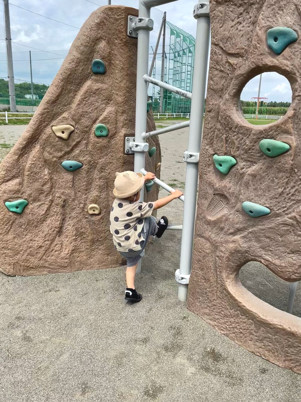 グレー系のその他パンツ、グリーン系のTシャツ/カットソー、ブラック系のサンダルを着用したキッズの夏コーディネートの2枚目の写真