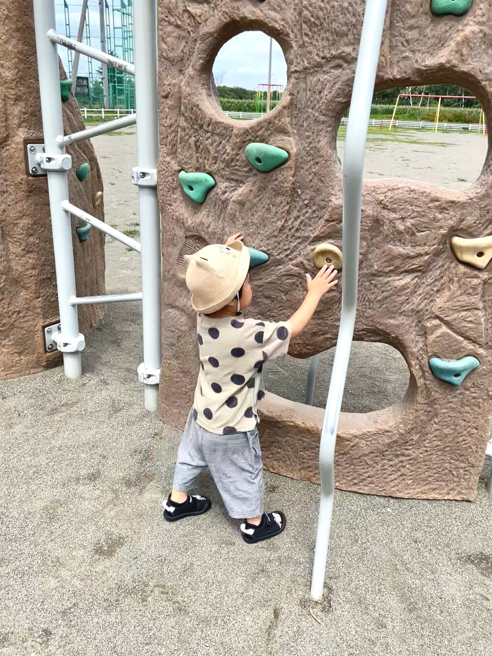 グレー系のその他パンツ、グリーン系のTシャツ/カットソー、ブラック系のサンダルを着用したキッズの夏コーディネートの3枚目の写真
