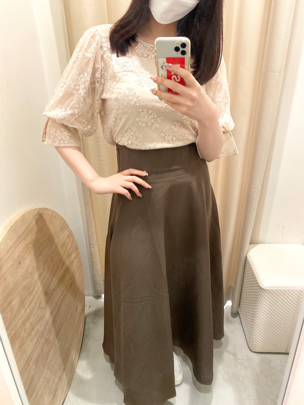 ベージュ系のトップス、ブラウン系のスカートを着用したレディースの春コーディネートの3枚目の写真