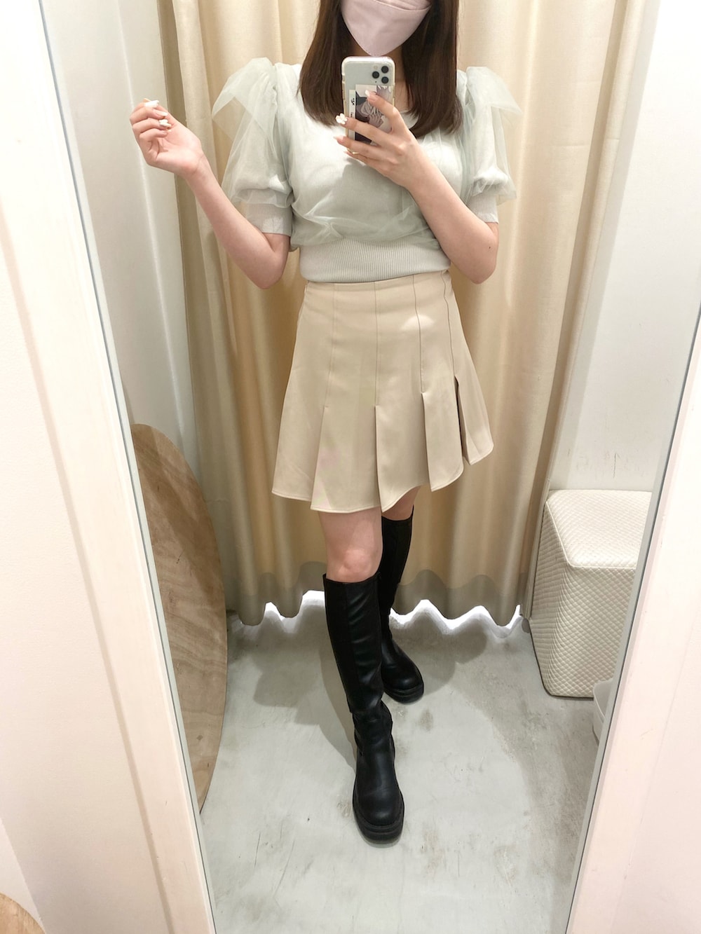 グリーン系のトップス、ベージュ系のスカート、ブラック系のブーツを着用したレディースの春コーディネートの4枚目の写真