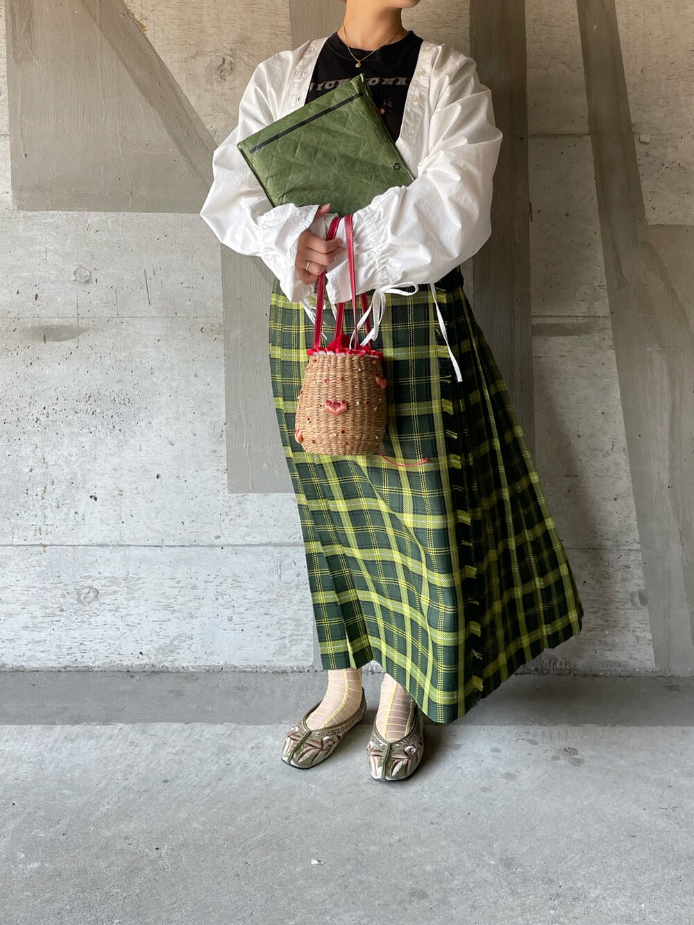 ブラック系のTシャツ/カットソー、ホワイト系のパンツ、グリーン系のスカートを着用したレディースの春コーディネートの2枚目の写真