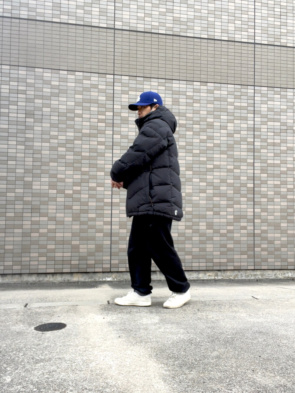 ブラック系のダウンジャケット/コート、ホワイト系のスニーカー、ブラック系のスウェットパンツを着用したメンズの冬コーディネートの2枚目の写真