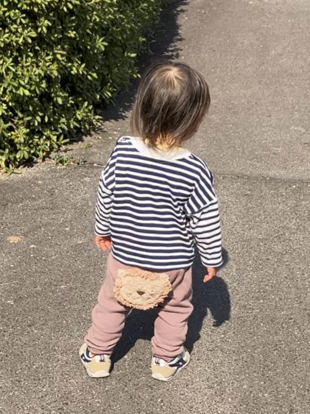 ホワイト系のTシャツ/カットソー、ブラウン系のその他パンツ、ベージュ系のスニーカーを着用したキッズの春コーディネートの2枚目の写真