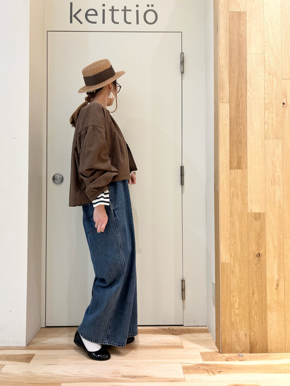 ブラウン系のノーカラージャケット、ブラック系のTシャツ/カットソー、ブルー系のサロペット/オーバーオールを着用したレディースの春コーディネートの2枚目の写真