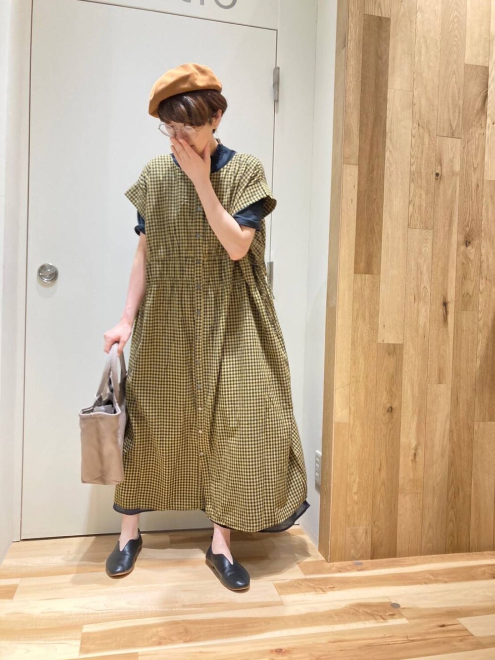 ベージュ系のバッグ、イエロー系のワンピース、ブラック系のTシャツ/カットソーを着用したレディースの夏コーディネートの2枚目の写真