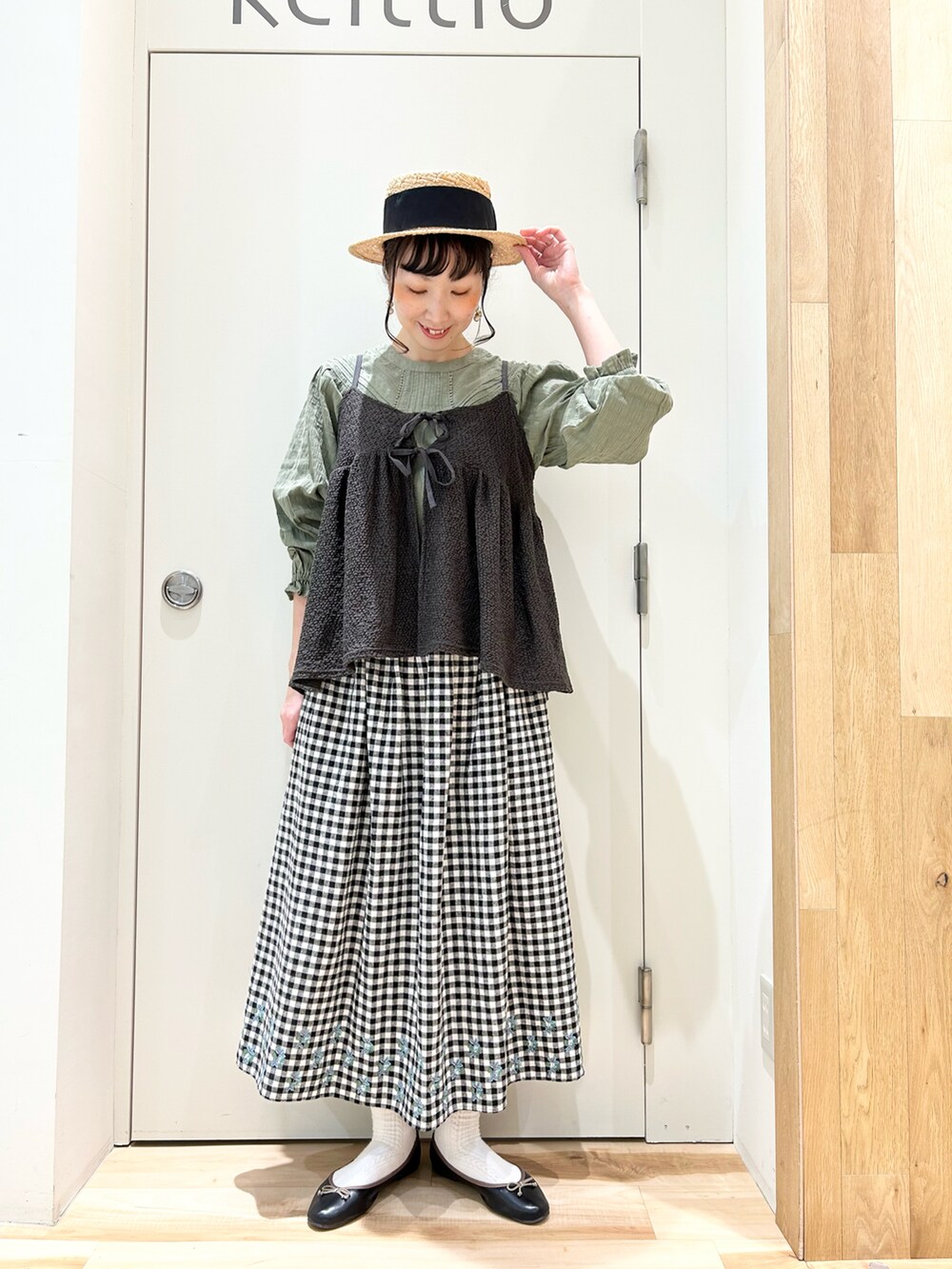 グリーン系のシャツ/ブラウス、ブラック系のスカート、グレー系のTシャツ/カットソーを着用したレディースの冬コーディネートの4枚目の写真