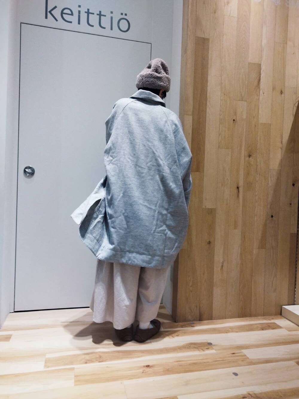 グリーン系のニット/セーター、グレー系のポンチョ、ホワイト系のその他パンツを着用したレディースの冬コーディネートの3枚目の写真