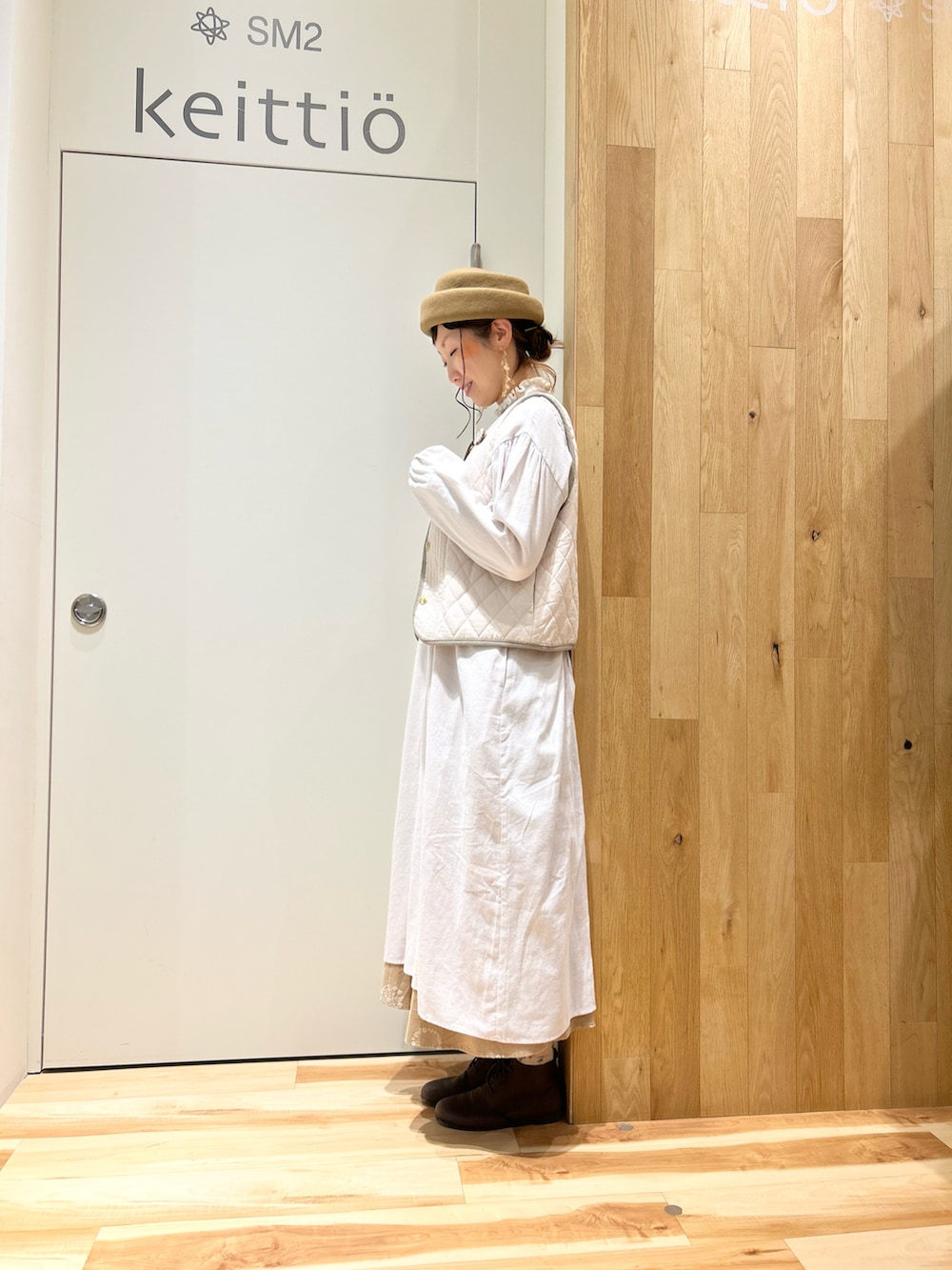 ベージュ系のノーカラージャケット、グレー系のワンピース、ホワイト系のベストを着用したレディースの冬コーディネートの5枚目の写真