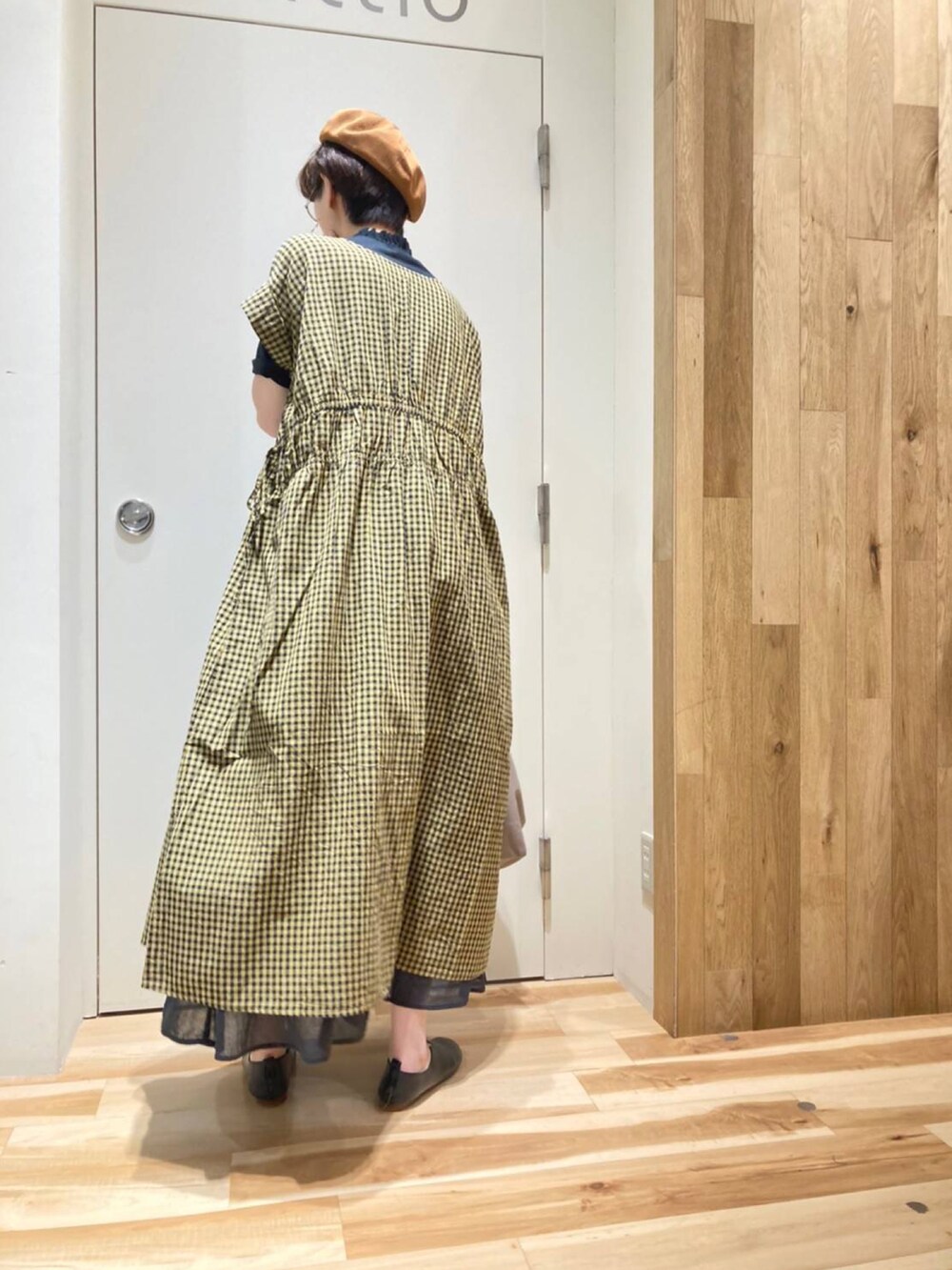 ベージュ系のバッグ、イエロー系のワンピース、ブラック系のTシャツ/カットソーを着用したレディースの夏コーディネートの3枚目の写真