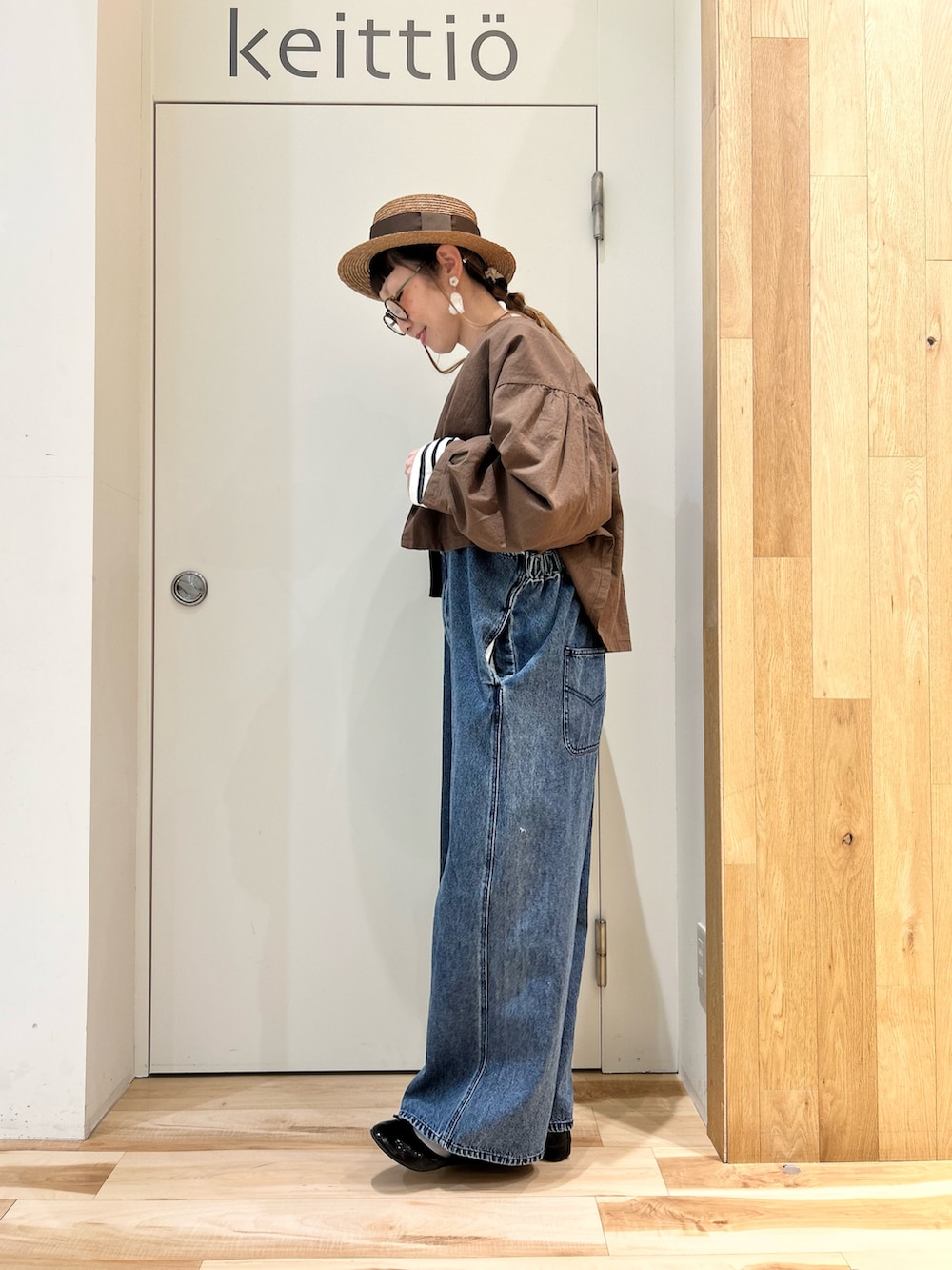 ブラウン系のノーカラージャケット、ブラック系のTシャツ/カットソー、ブルー系のサロペット/オーバーオールを着用したレディースの春コーディネートの3枚目の写真