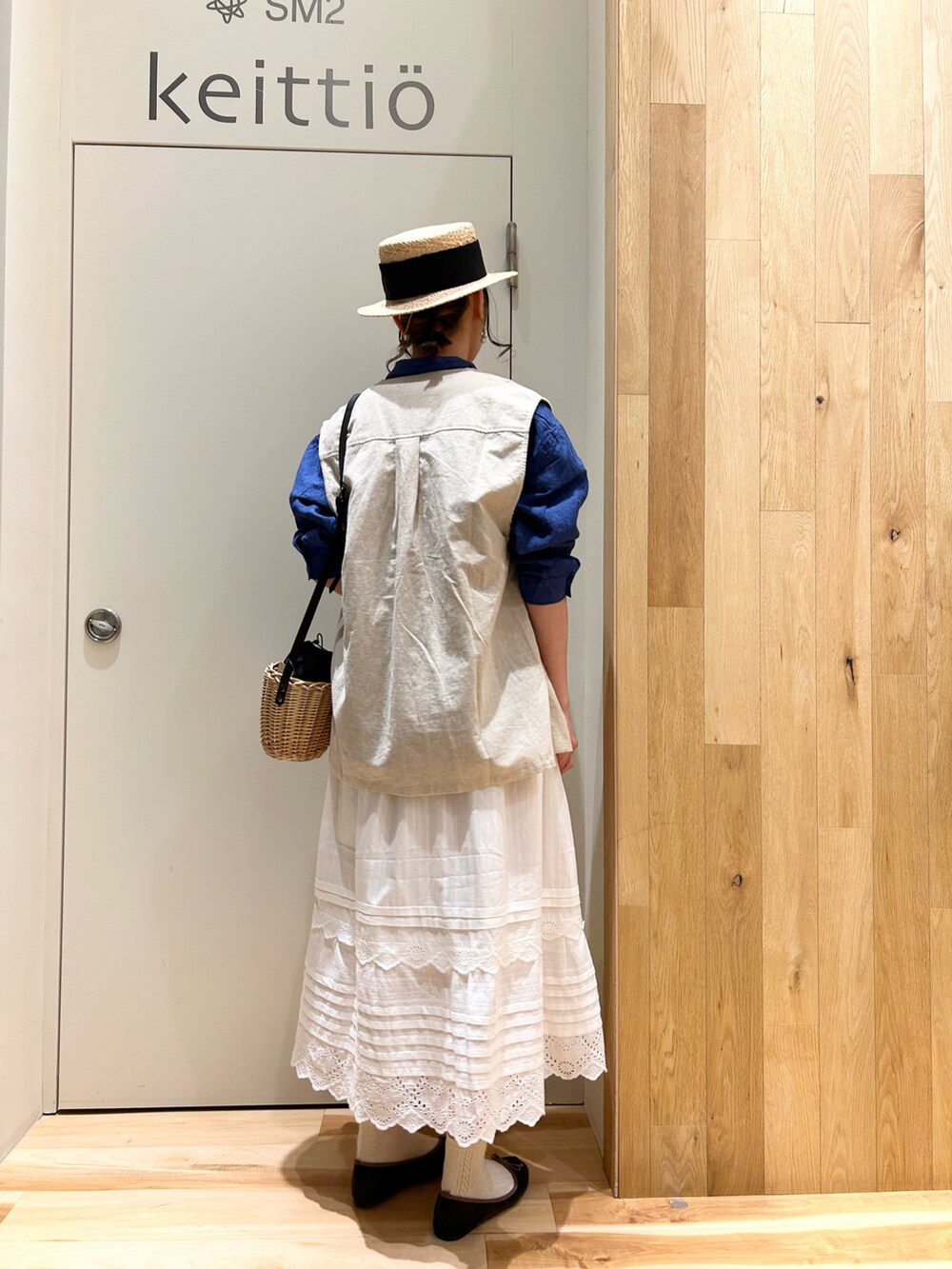ブルー系のシャツ/ブラウス、ホワイト系のスカート、ブラック系のドレスシューズを着用したレディースの春コーディネートの5枚目の写真