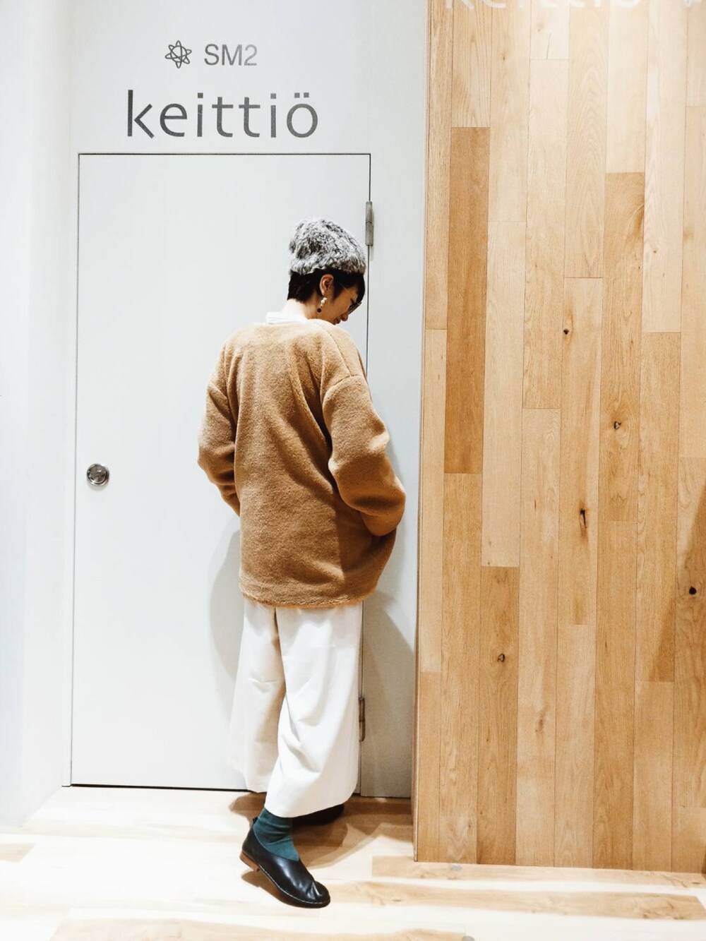 ベージュ系のノーカラーコート、ホワイト系のその他パンツ、ブラック系のその他シューズを着用したレディースの冬コーディネートの3枚目の写真