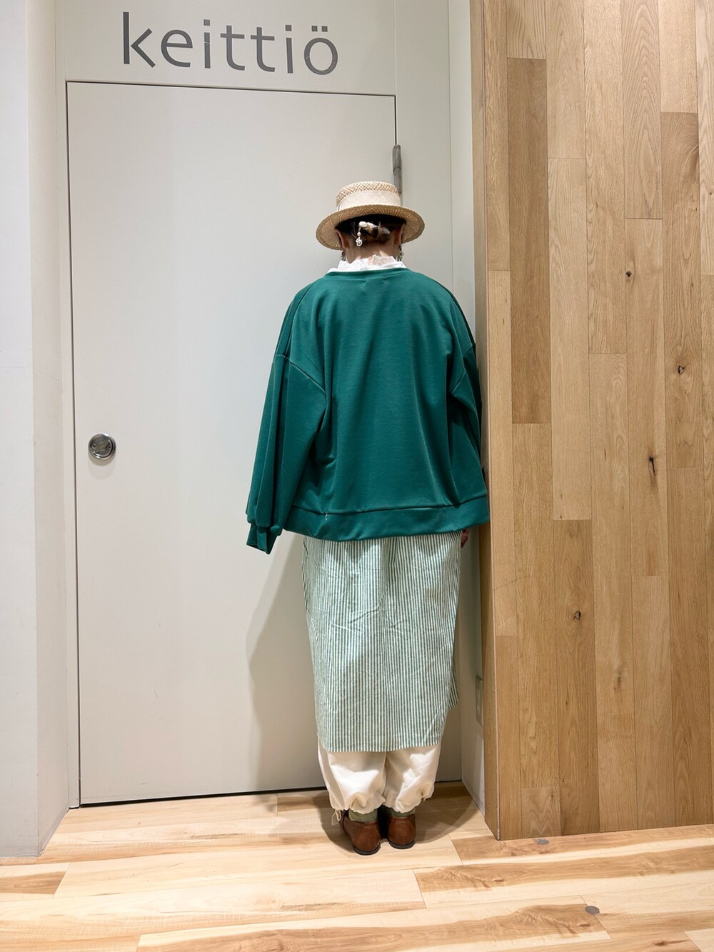 グリーン系のカーディガン/ボレロ、ホワイト系のシャツ/ブラウス、グリーン系のワンピースを着用したレディースの冬コーディネートの2枚目の写真