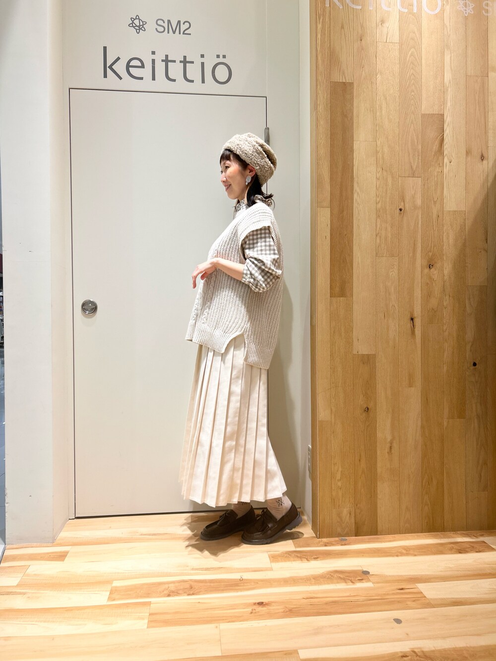 ベージュ系のシャツ/ブラウス、ベージュ系のステンカラーコート、ホワイト系のスカートを着用したレディースの冬コーディネートの5枚目の写真