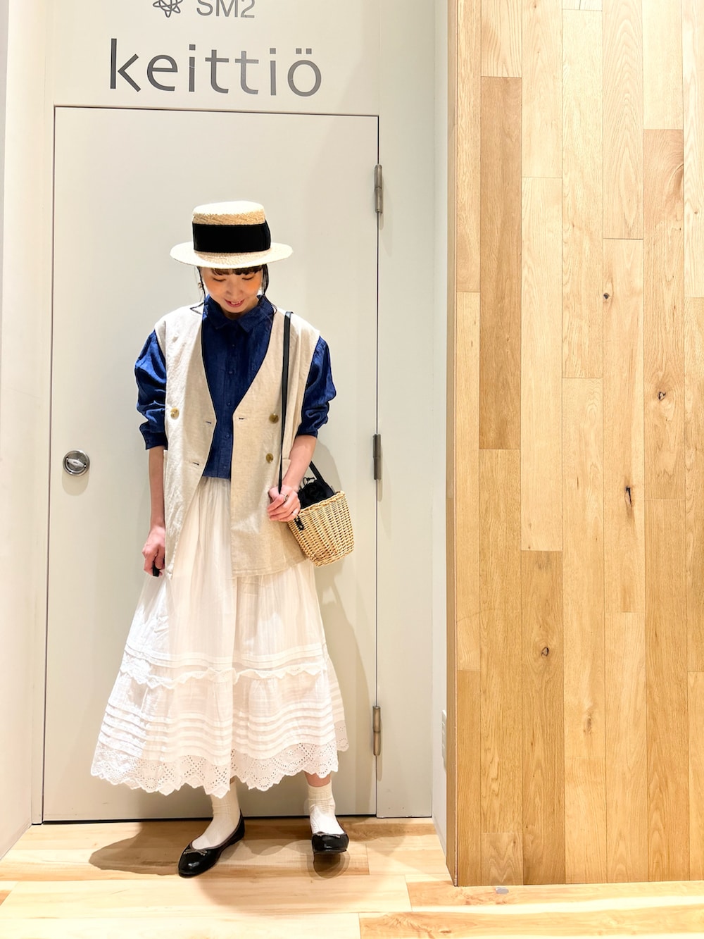 ブルー系のシャツ/ブラウス、ホワイト系のスカート、ブラック系のドレスシューズを着用したレディースの春コーディネートの4枚目の写真
