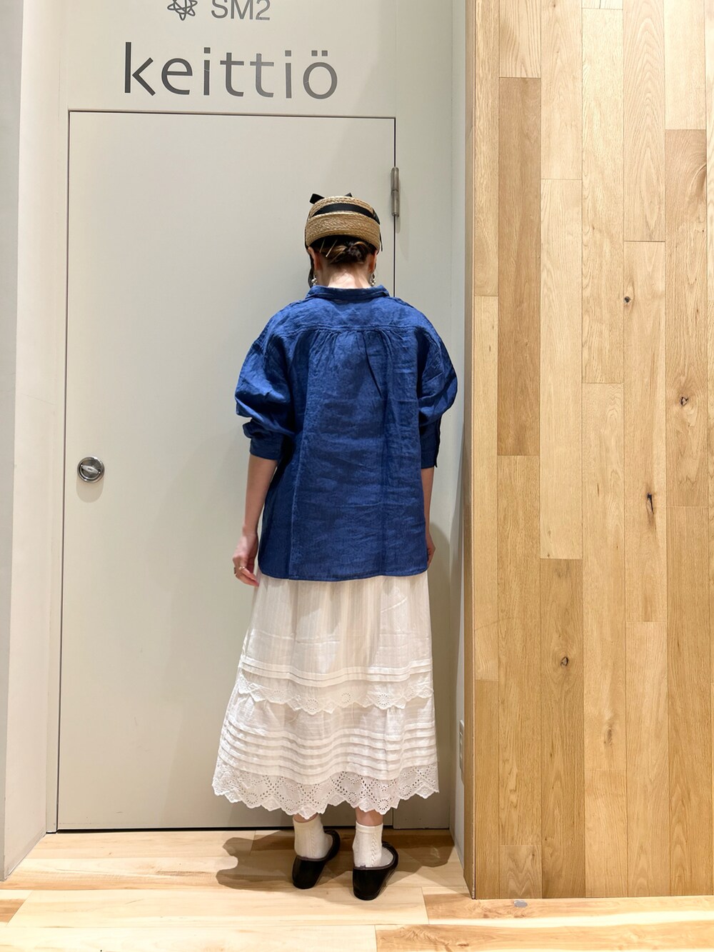 ブルー系のシャツ/ブラウス、ホワイト系のスカート、ブラック系のドレスシューズを着用したレディースの春コーディネートの2枚目の写真