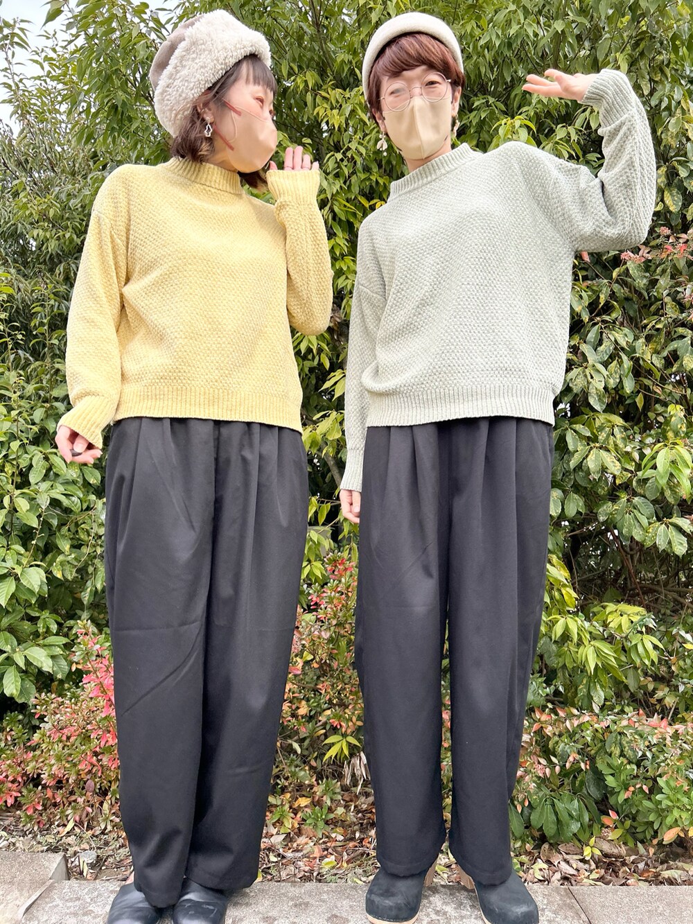 イエロー系のニット/セーター、ブラック系のスラックスを着用したレディースの冬コーディネートの2枚目の写真