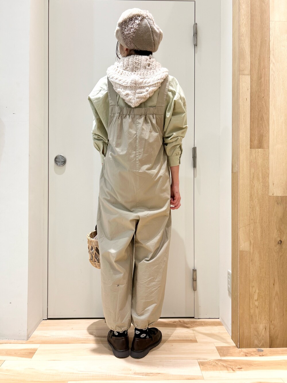 グリーン系のシャツ/ブラウス、ベージュ系のサロペット/オーバーオール、ベージュ系のハンドバッグを着用したレディースの冬コーディネートの2枚目の写真