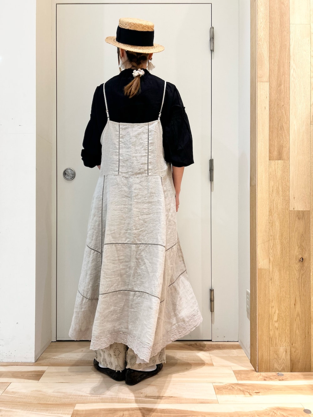 ブラック系のシャツ/ブラウス、ベージュ系のワンピース/ドレス、ベージュ系のパンツを着用したレディースの春コーディネートの3枚目の写真