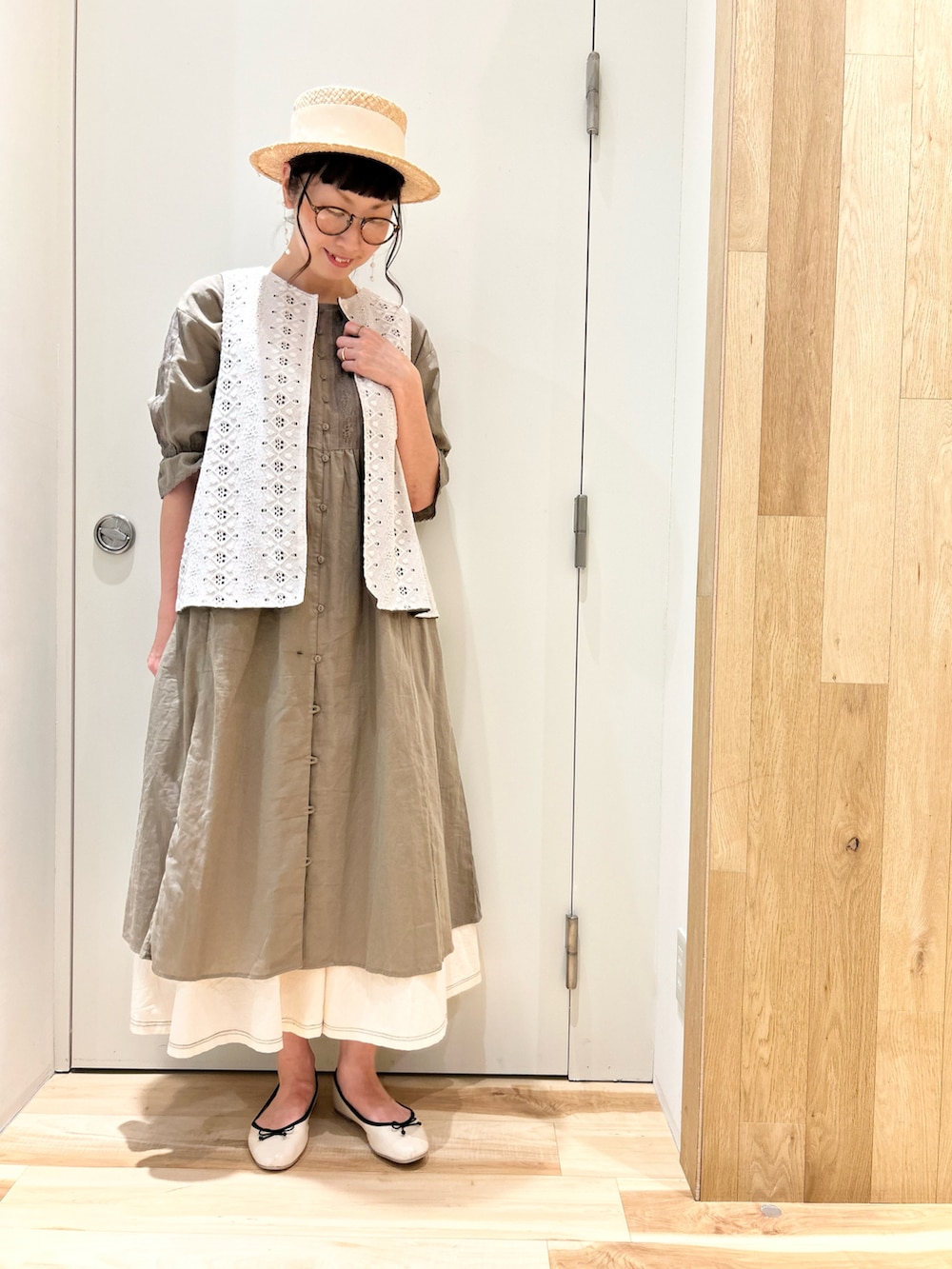 グリーン系のワンピース、ホワイト系のベスト、ホワイト系のスカートを着用したレディースの夏コーディネートの2枚目の写真