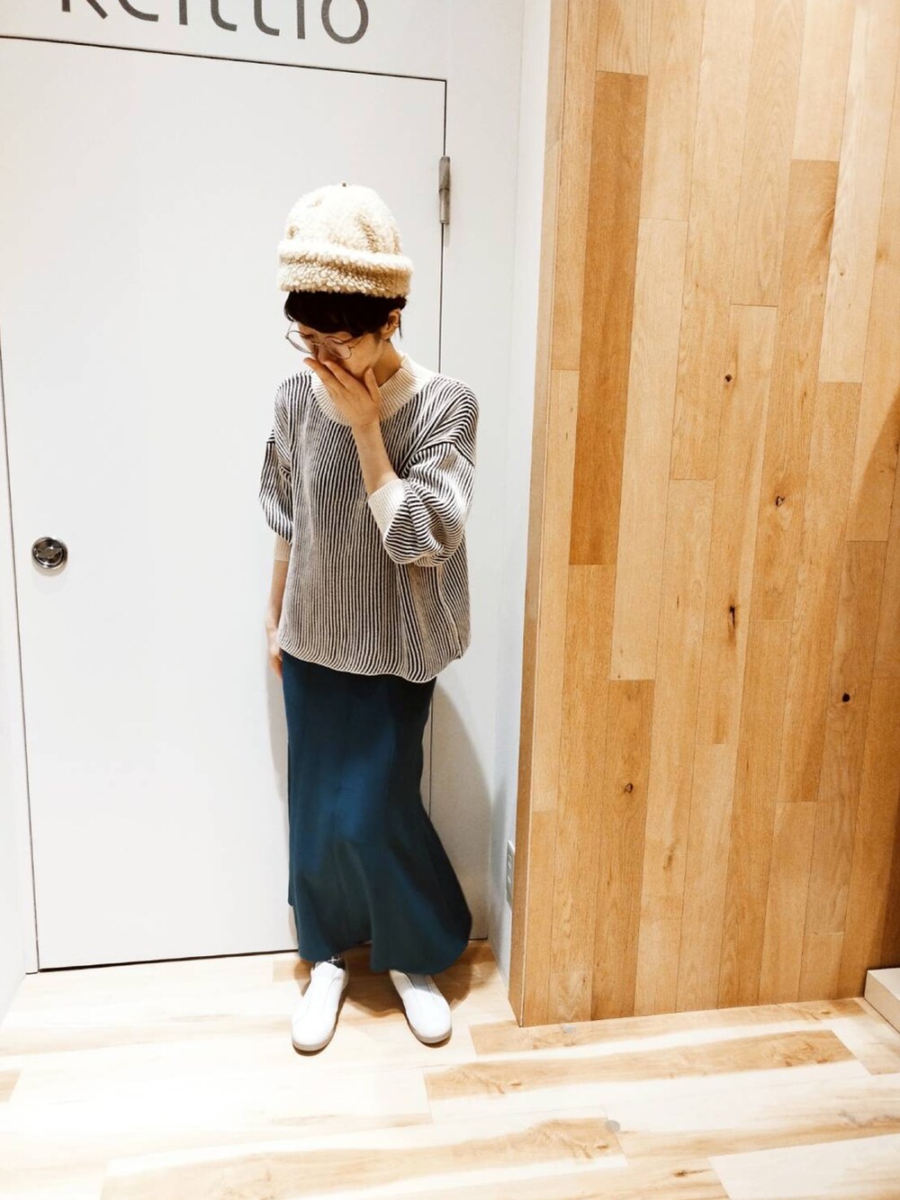 グリーン系のスカート、ブラック系のニット/セーターを着用したレディースの冬コーディネートの3枚目の写真