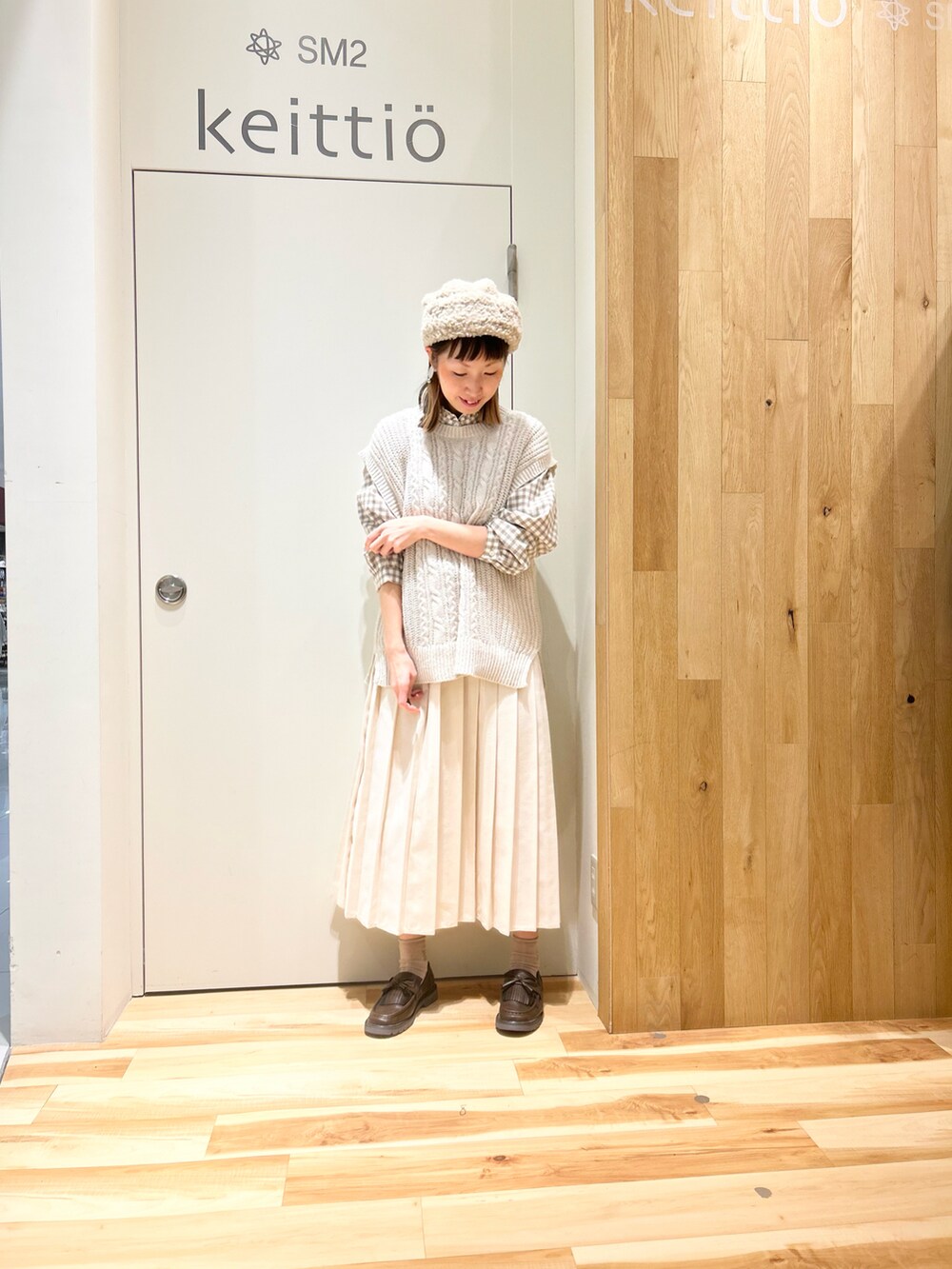 ベージュ系のシャツ/ブラウス、ベージュ系のステンカラーコート、ホワイト系のスカートを着用したレディースの冬コーディネートの4枚目の写真