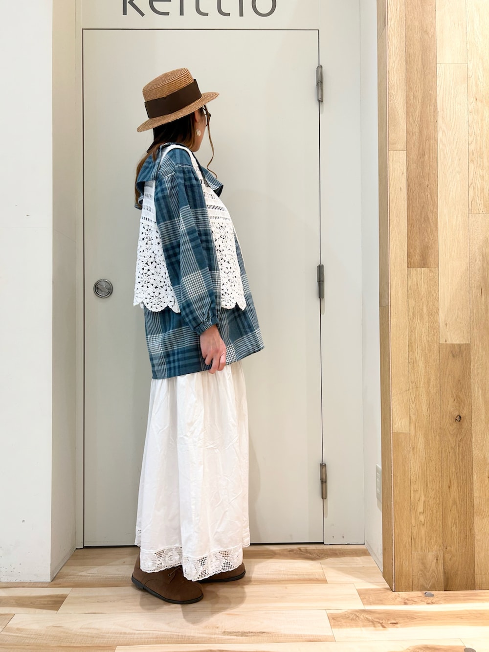 グリーン系のシャツ/ブラウス、ホワイト系のベスト、ホワイト系のスカートを着用したレディースの春コーディネートの2枚目の写真