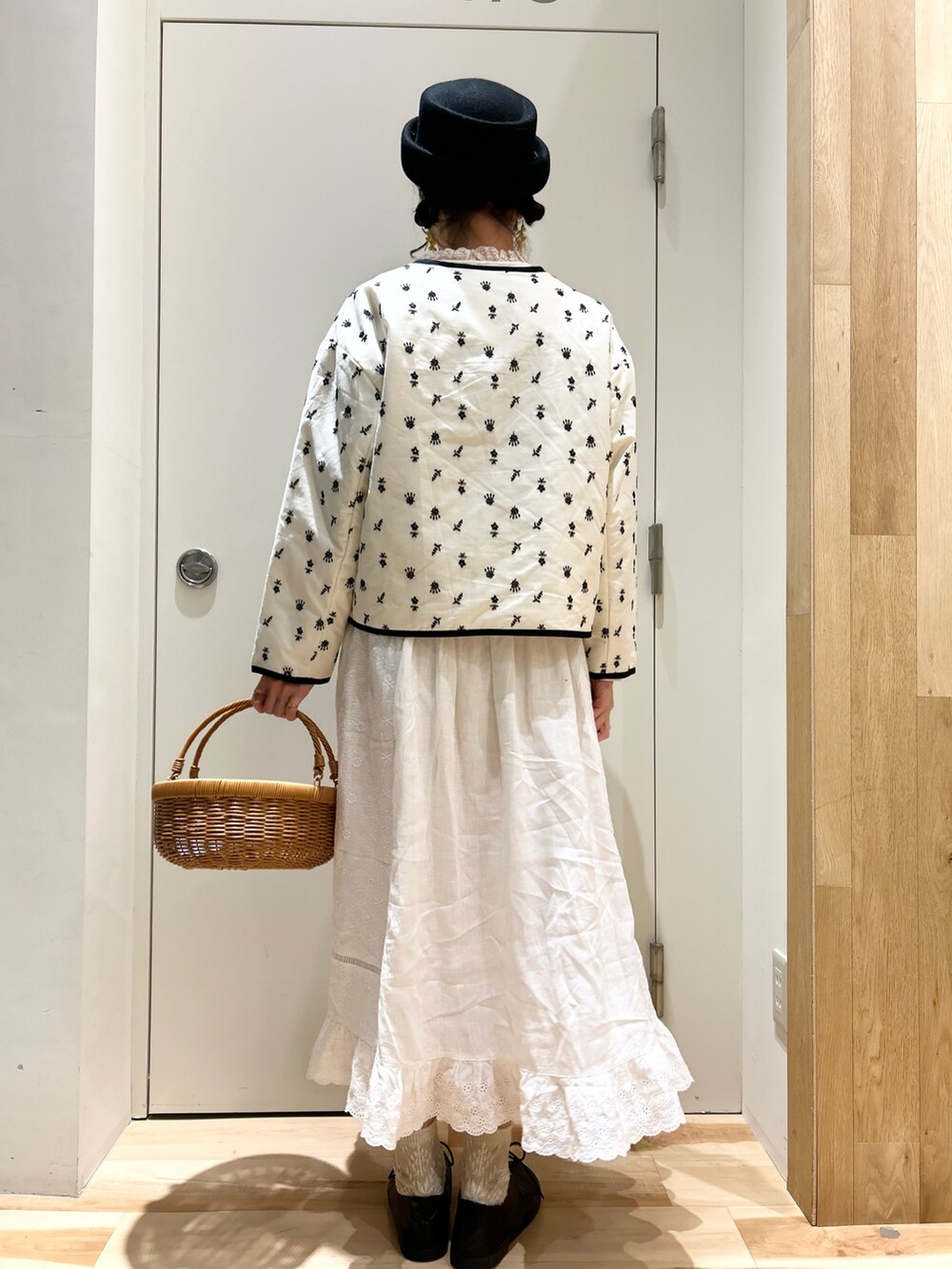 ベージュ系のシャツ/ブラウス、ホワイト系のジャケット/アウター、ブラック系のハットを着用したレディースの冬コーディネートの2枚目の写真