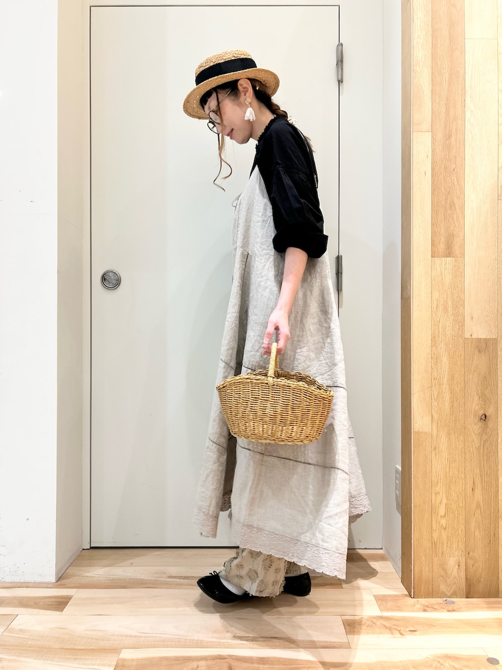 ブラック系のシャツ/ブラウス、ベージュ系のワンピース/ドレス、ベージュ系のパンツを着用したレディースの春コーディネートの2枚目の写真