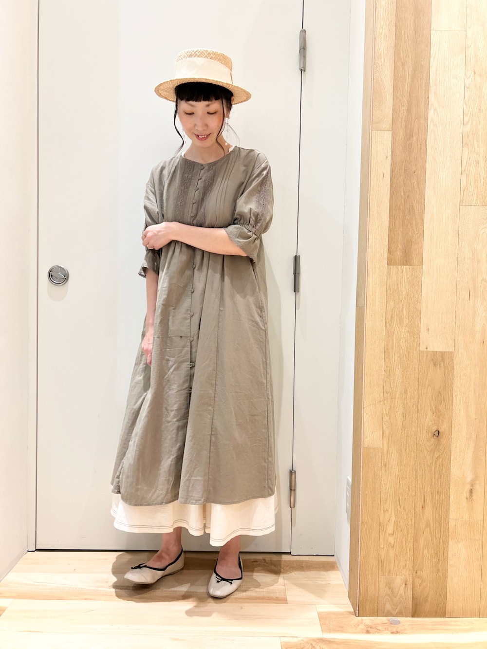 グリーン系のワンピース、ホワイト系のベスト、ホワイト系のスカートを着用したレディースの夏コーディネートの3枚目の写真