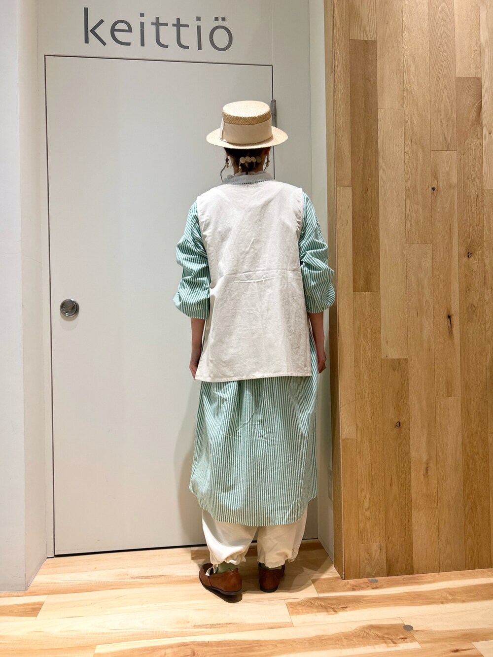 グリーン系のカーディガン/ボレロ、ホワイト系のシャツ/ブラウス、グリーン系のワンピースを着用したレディースの冬コーディネートの4枚目の写真