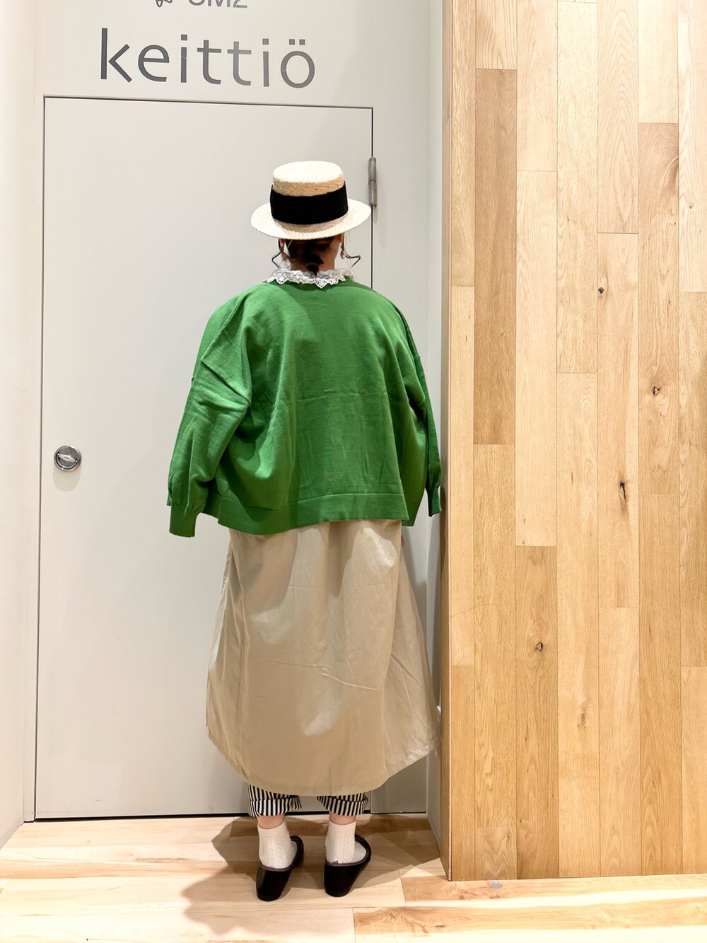 ホワイト系のシャツ/ブラウス、グリーン系のカーディガン/ボレロ、ベージュ系のシャツワンピースを着用したレディースの春コーディネートの2枚目の写真