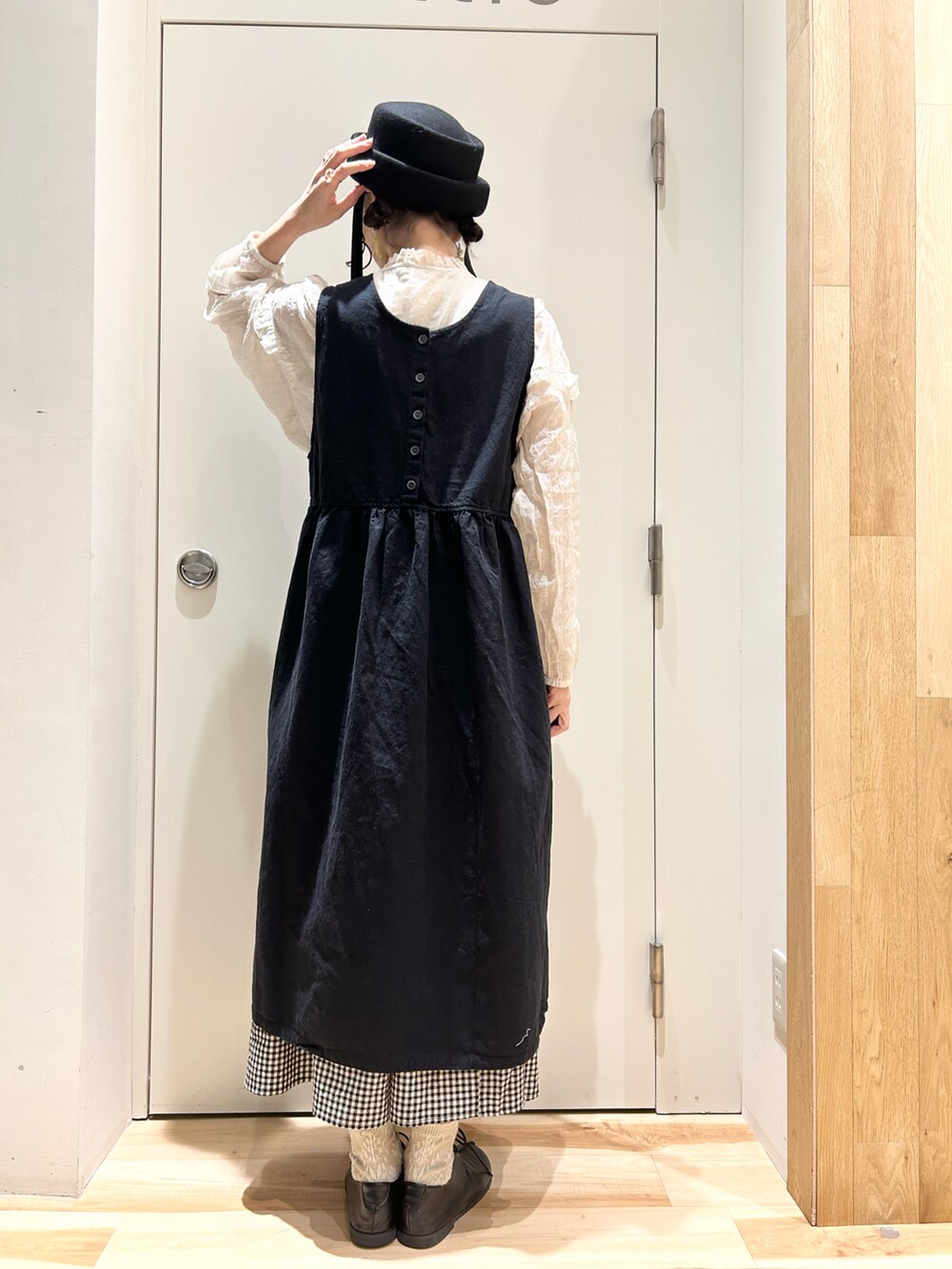 ベージュ系のシャツ/ブラウス、ブラック系のジャンパースカート、ブラック系のスカートを着用したレディースの冬コーディネートの3枚目の写真