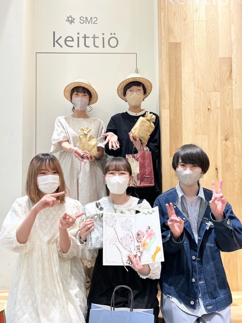 ブラック系のチュニック、ブルー系のノーカラージャケット、ホワイト系のハットを着用したレディースの春コーディネートの2枚目の写真