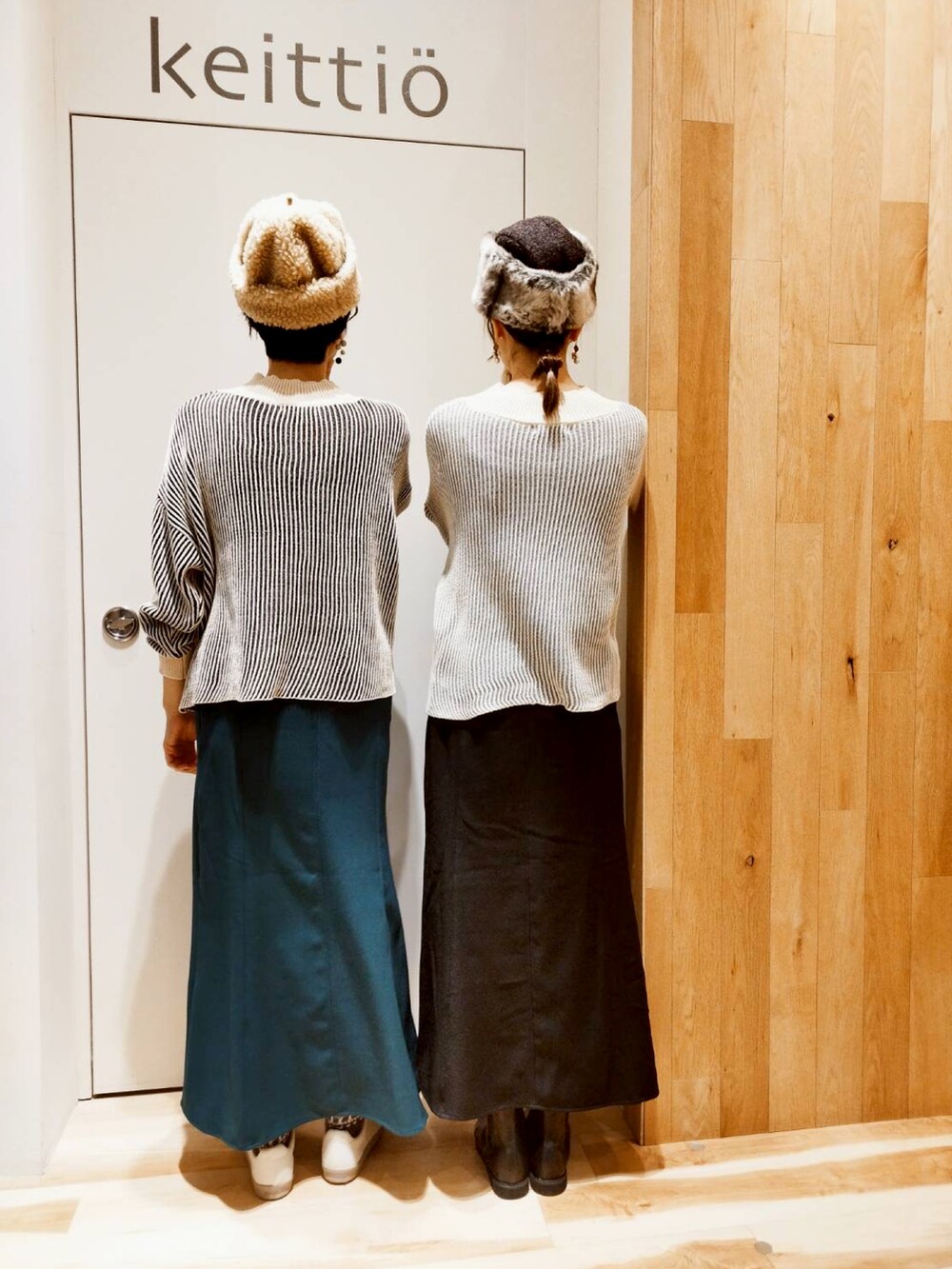 グリーン系のスカート、ブラック系のニット/セーターを着用したレディースの冬コーディネートの2枚目の写真