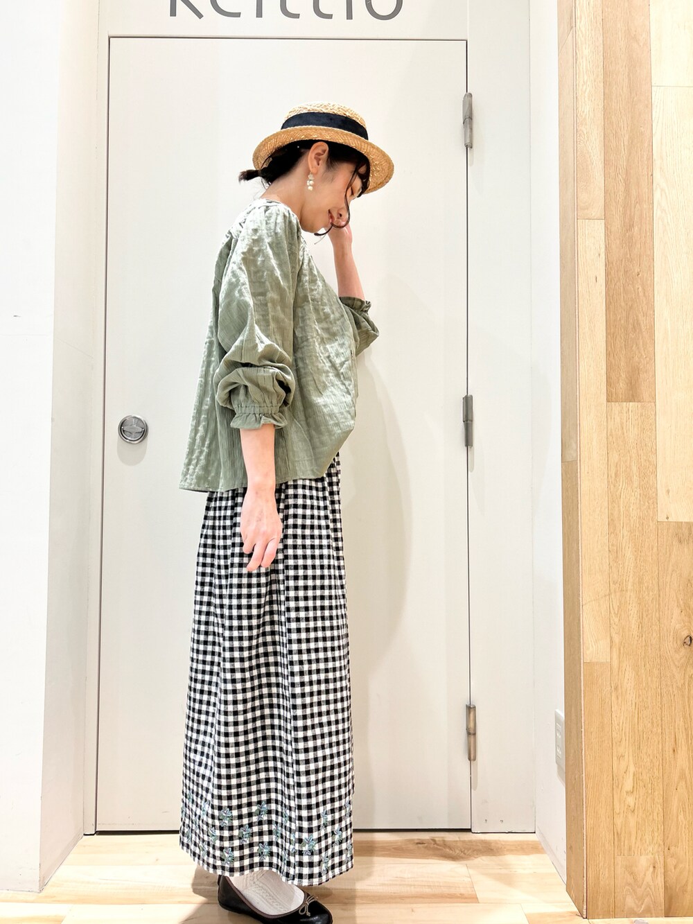 グリーン系のシャツ/ブラウス、ブラック系のスカート、グレー系のTシャツ/カットソーを着用したレディースの冬コーディネートの2枚目の写真