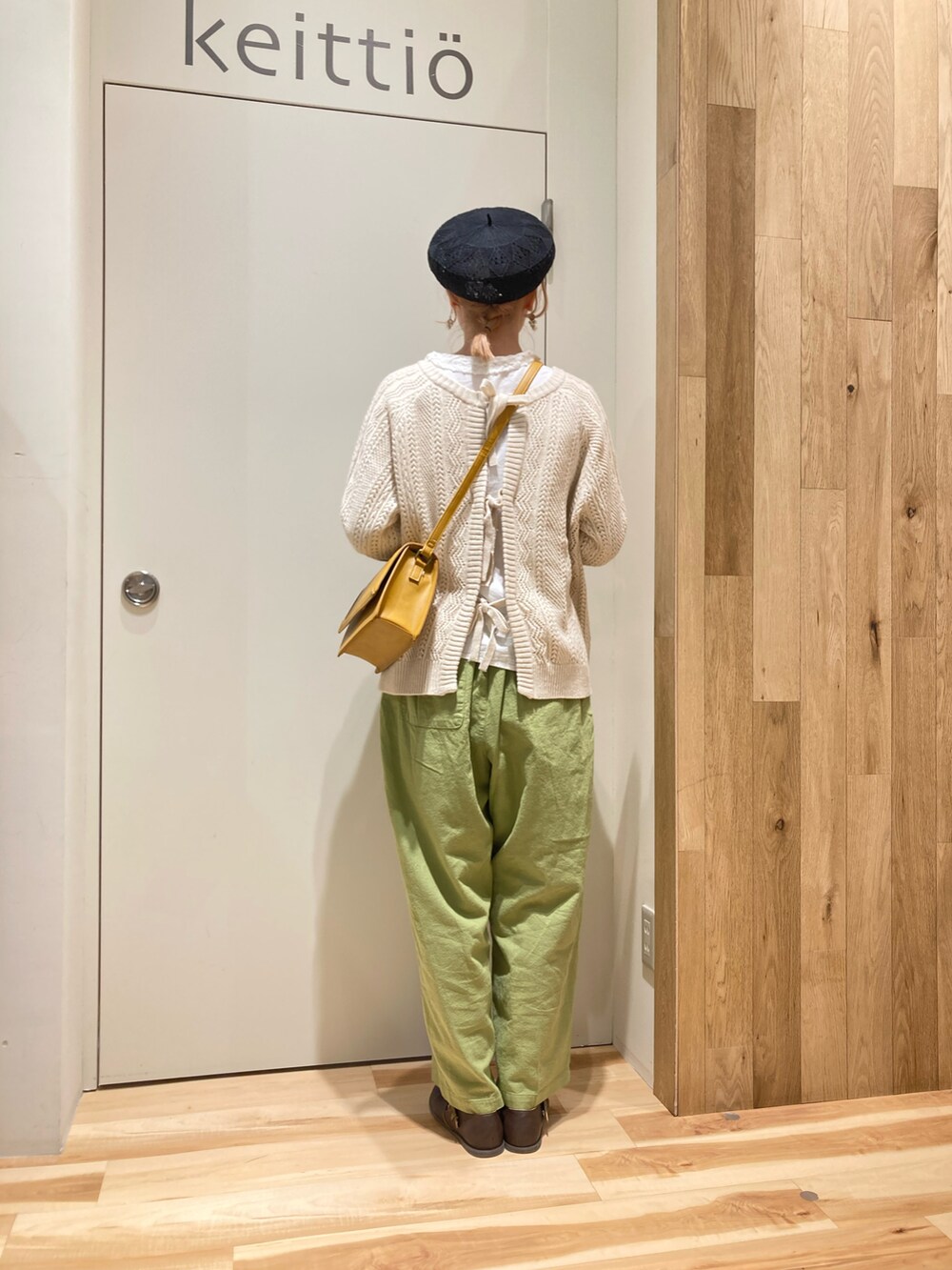 グリーン系のその他パンツ、イエロー系のショルダーバッグ、ホワイト系のニット/セーターを着用したレディースの冬コーディネートの3枚目の写真