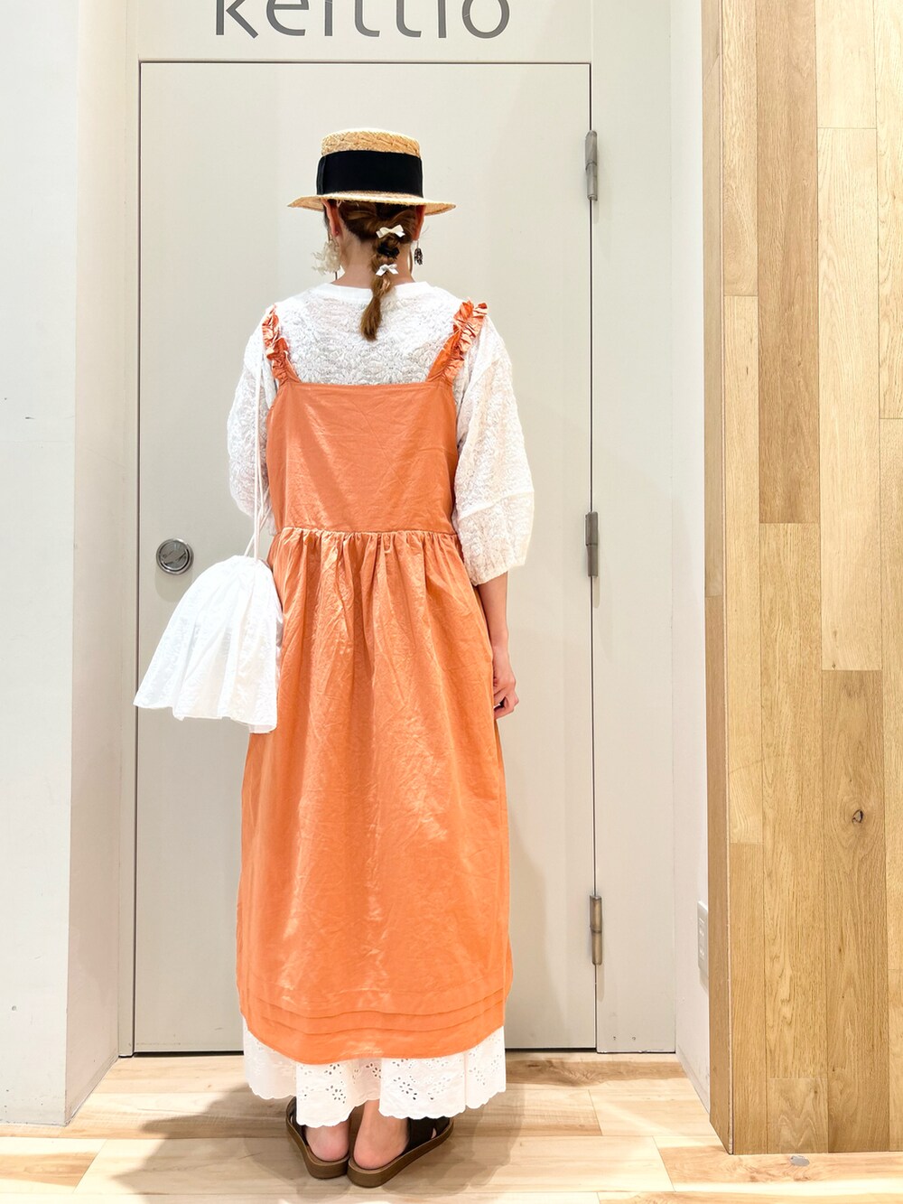 オレンジ系のワンピース/ドレス、ホワイト系のTシャツ/カットソー、ホワイト系のハンドバッグを着用したレディースの夏コーディネートの3枚目の写真