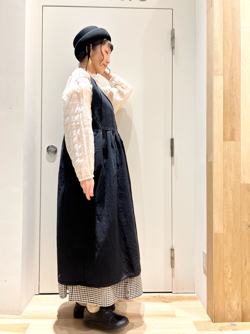 ベージュ系のシャツ/ブラウス、ブラック系のジャンパースカート、ブラック系のスカートを着用したレディースの冬コーディネートの2枚目の写真