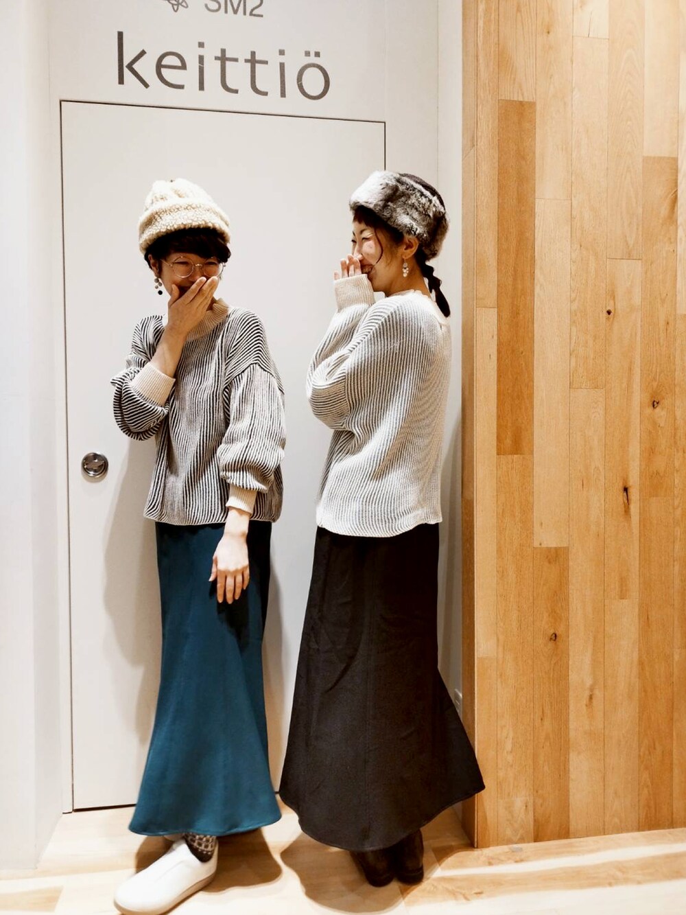 グリーン系のスカート、ブラック系のニット/セーターを着用したレディースの冬コーディネートの3枚目の写真